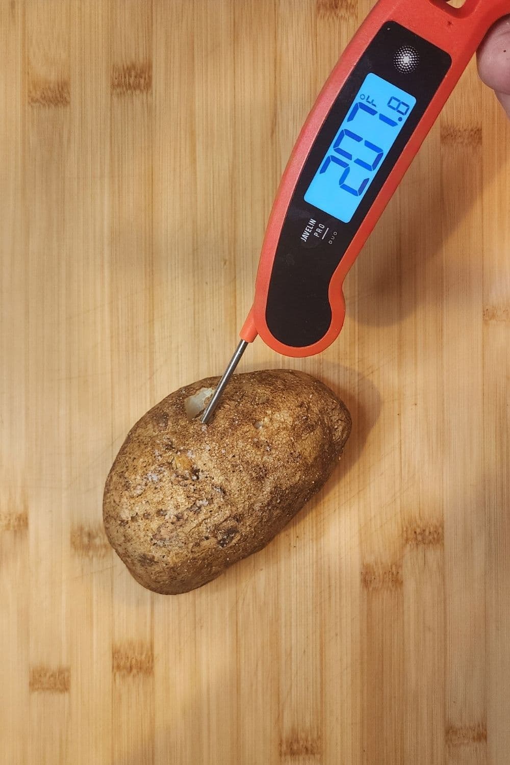 Thermometer showing 207°F in baked potato
