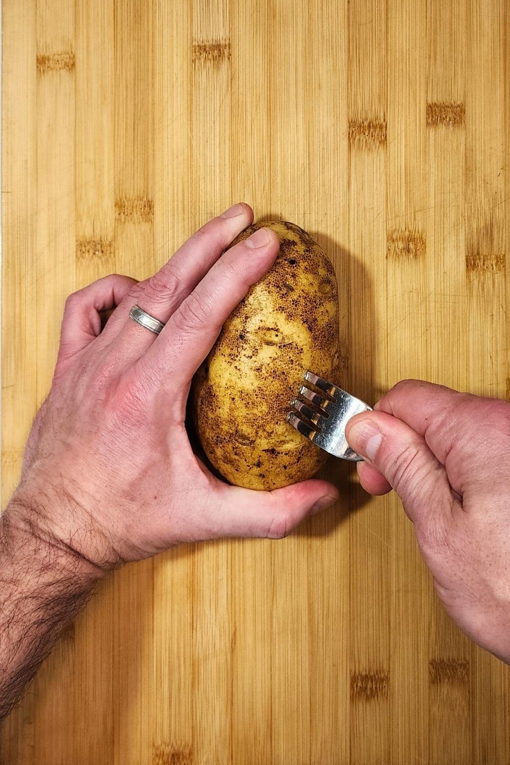 Piercing potato with fork before baking