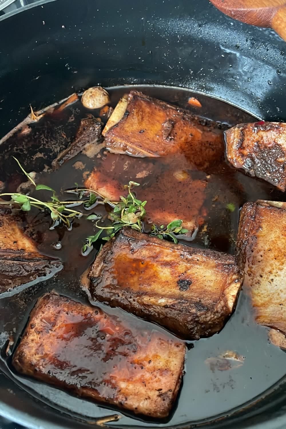 Braised short ribs with glossy wine sauce showing fall-off-the-bone tender meat