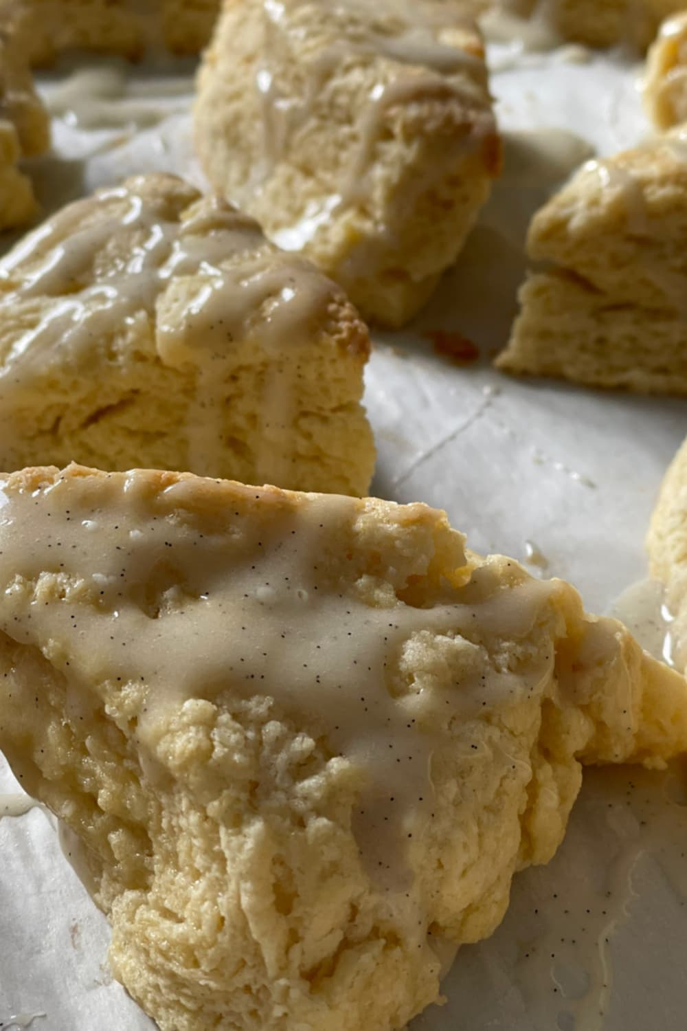 Flaky vanilla scones with glaze showing layered texture